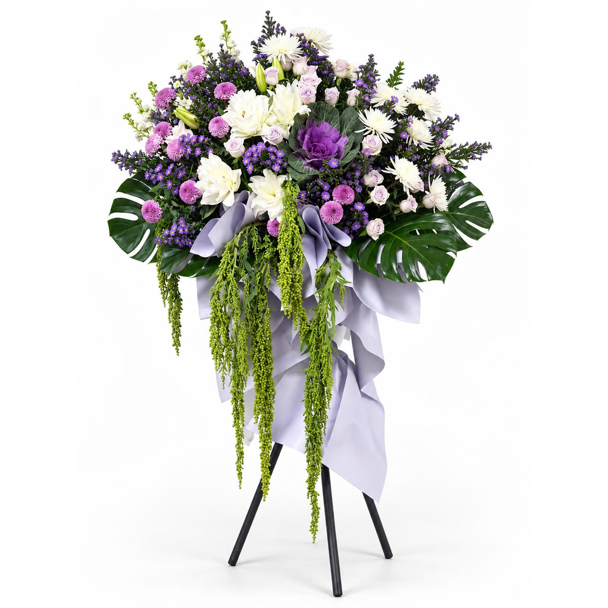 Lavender Serenity condolence flower stand with light purple roses, white roselilies, purple brassica and purple chrysanthemums