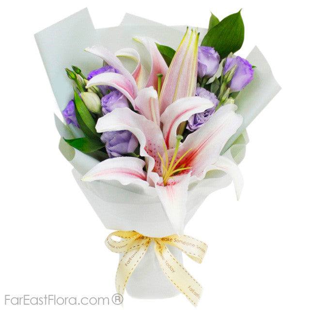 MYVAMZ004 - My Heart's Song petite bouquet with pink lilies, purple eustomas, greenery and cream ribbon wrap