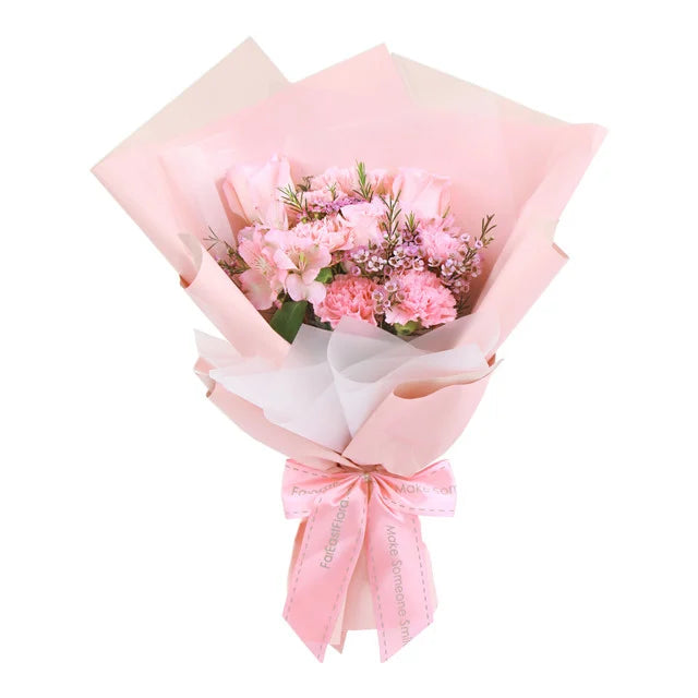 Bouquet of pink carnations and roses with alstroemerias and wax flowers wrapped in pink paper