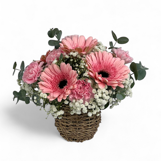 Close-up of Sugar Petals fresh flower arrangement with soft pink gerbera and carnations in a decorative basket.